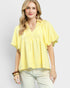 Woman wearing a yellow checkered blouse against a white background