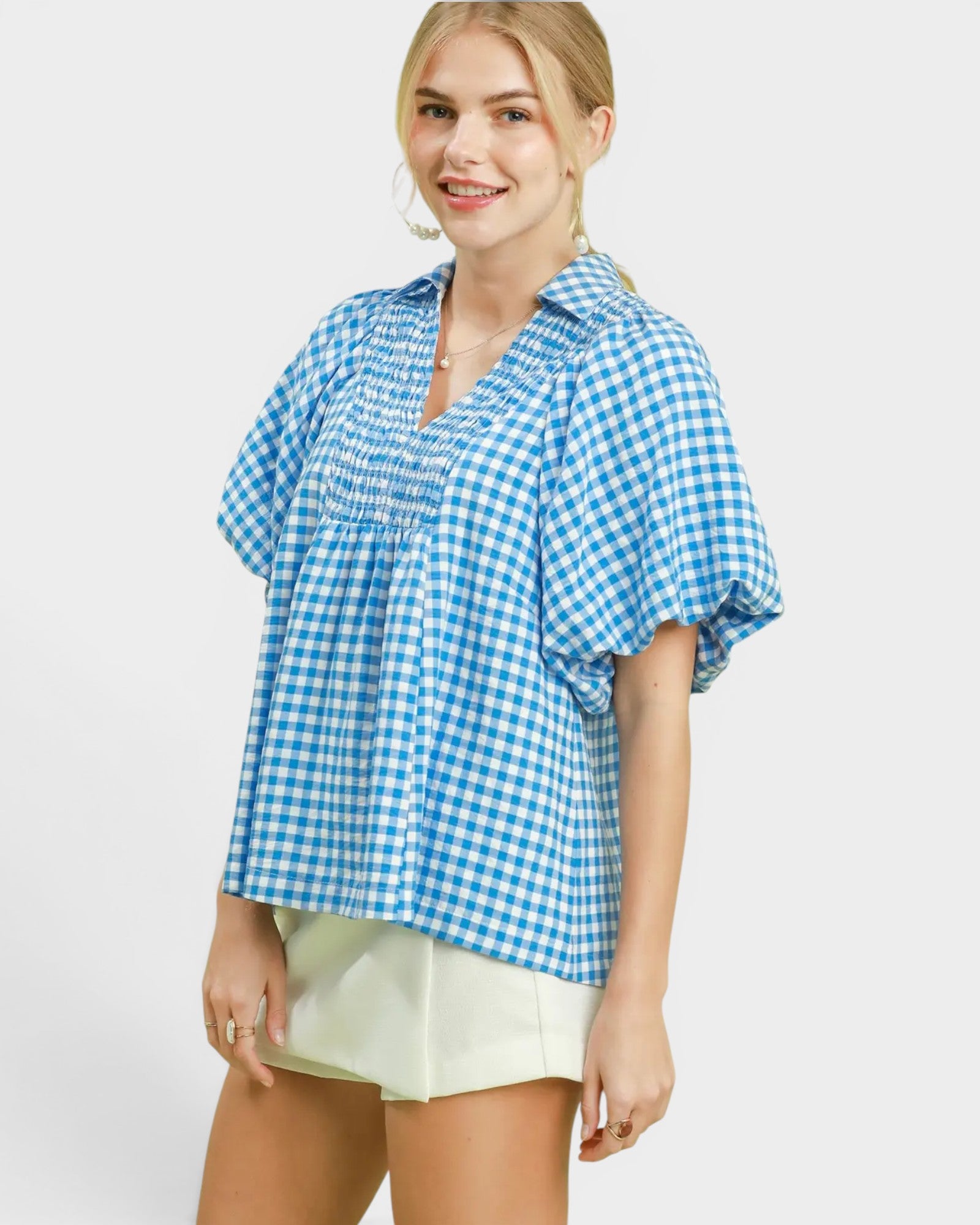 Woman wearing a blue and white checkered blouse on a white background