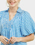 Woman wearing a blue and white checkered dress with a plain background