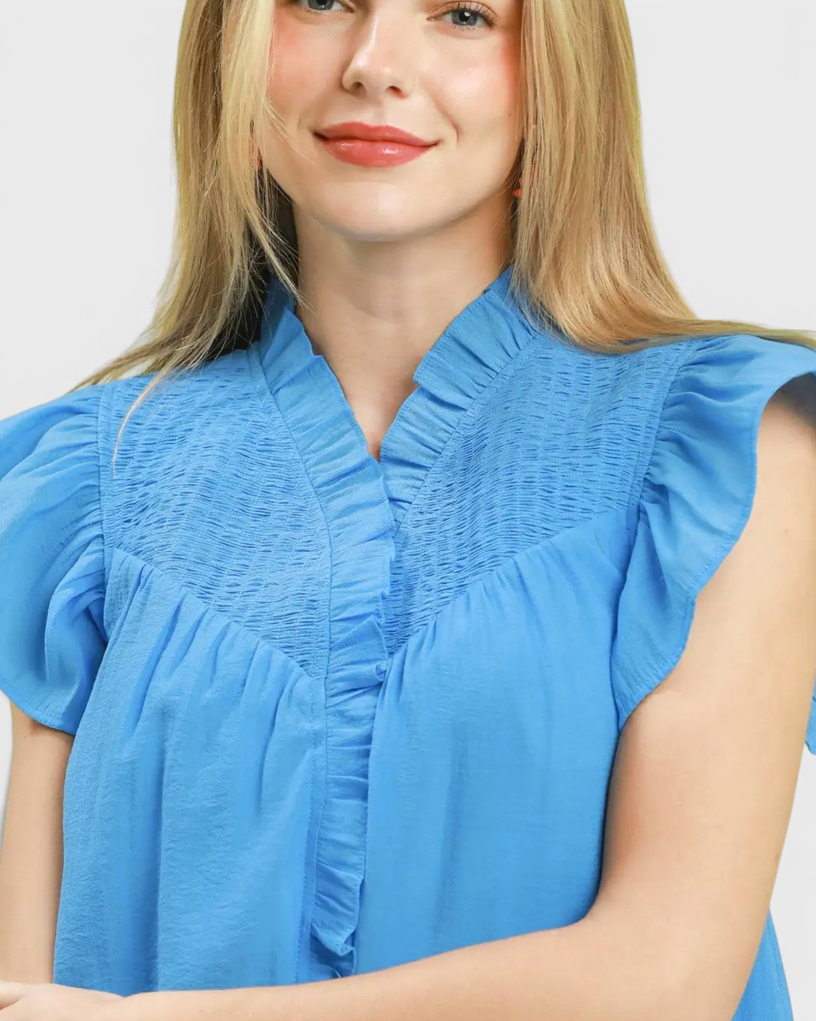 Woman wearing a blue blouse with a plain background