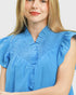 Woman wearing a blue blouse with a plain background
