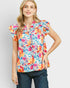 Woman wearing a colorful floral blouse against a light gray background