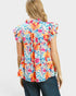 Woman wearing a colorful floral blouse on a white background
