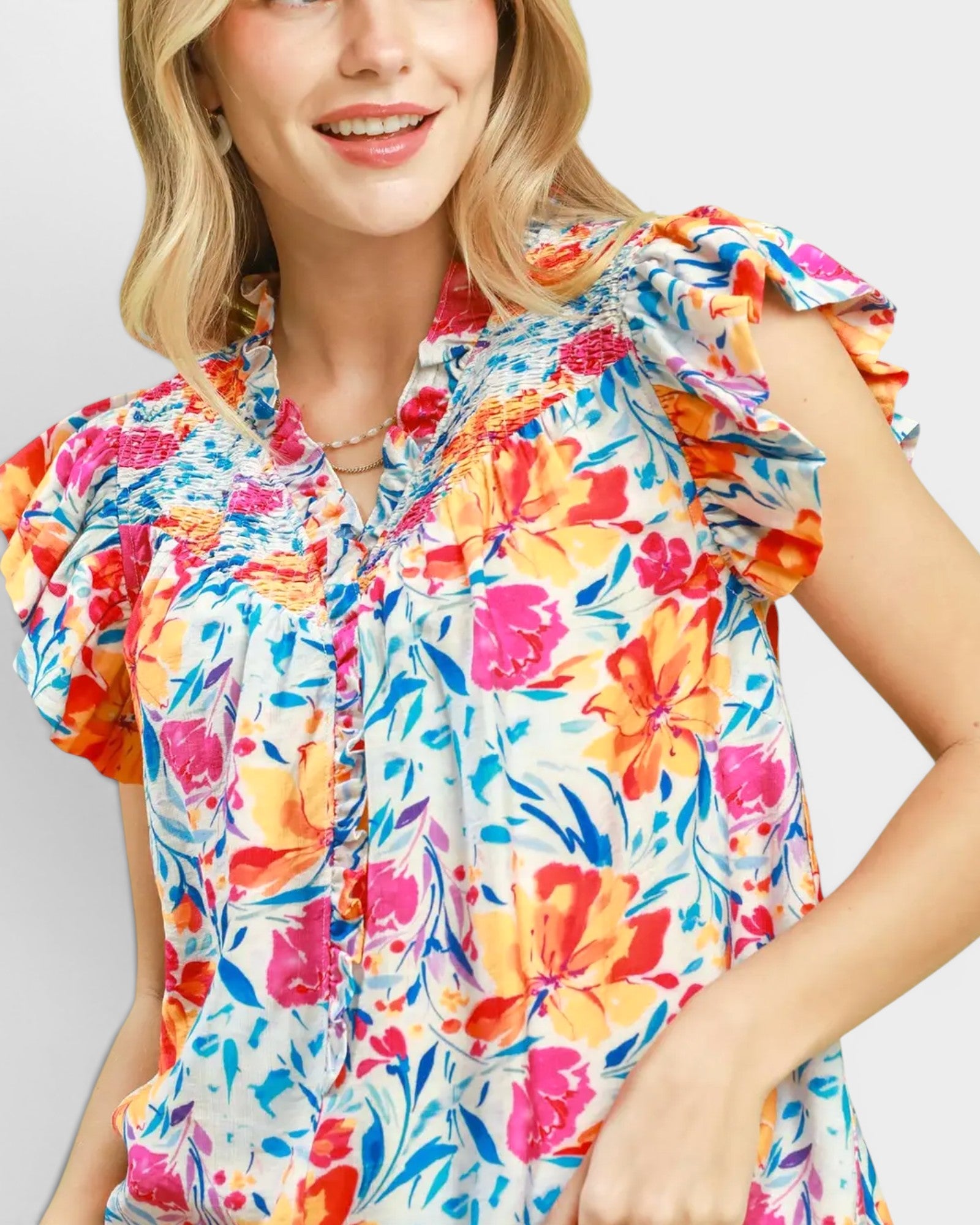 Woman wearing a colorful floral shirt on a plain background