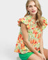 Woman wearing a colorful floral blouse with ruffled sleeves on a white background