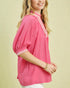Woman wearing a pink blouse with white trim on a beige background