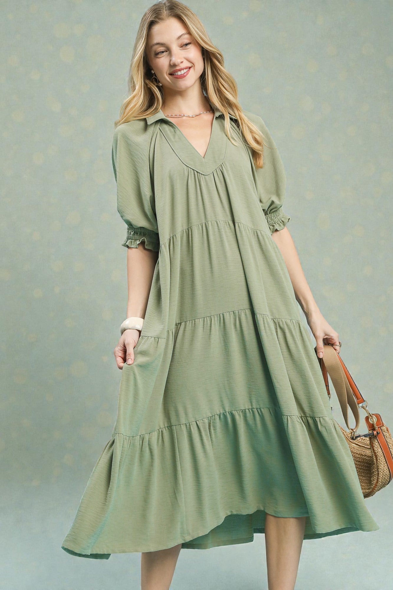 Woman wearing a green dress with a textured gray background