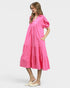Woman wearing a pink dress with puff sleeves on a white background