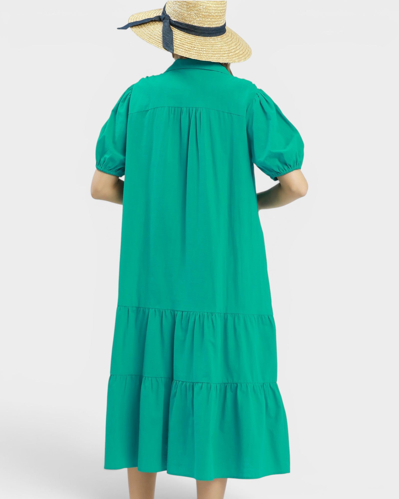 Green dress with puff sleeves and a hat on a white background