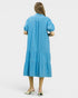 Woman wearing a blue dress with puff sleeves on a white background