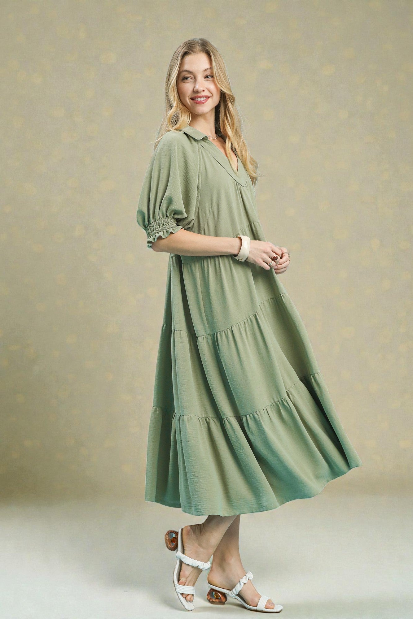 Woman wearing a green dress against a beige background