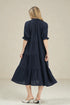 Woman wearing a navy blue dress with a plain background