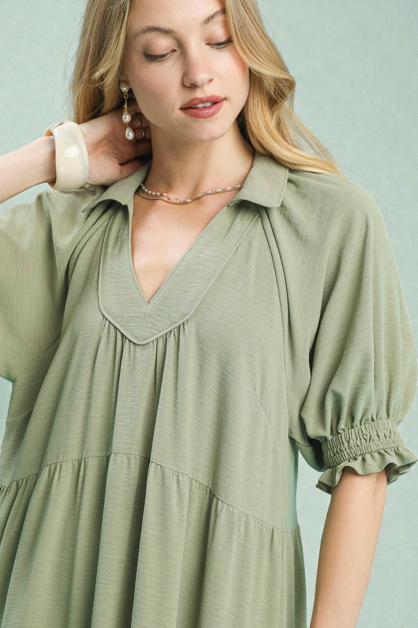 Woman wearing a green dress with a plain background