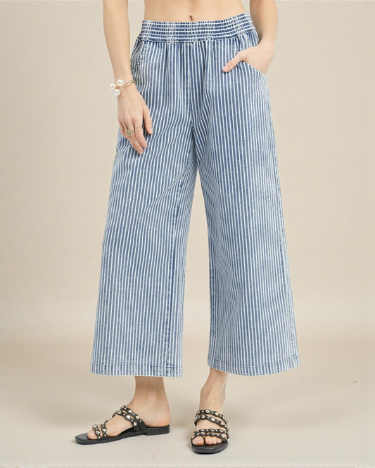 Blue and white striped wide-leg pants worn by a person on a beige background
