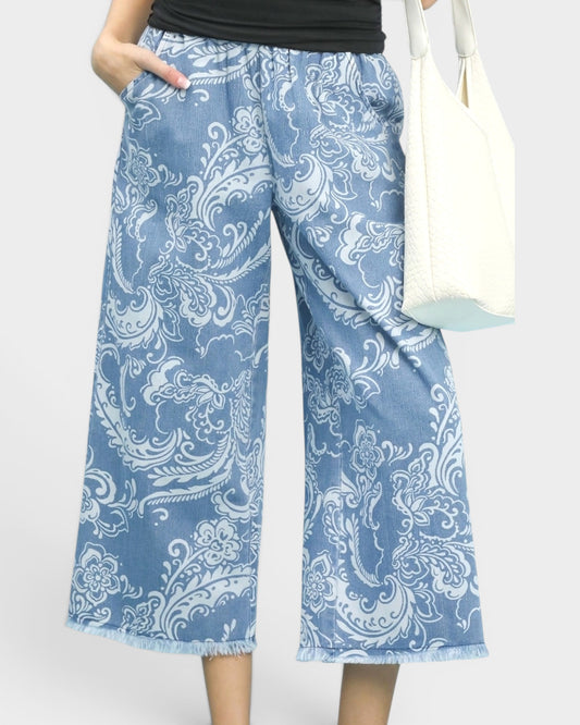 Blue patterned pants worn by a person on a white background