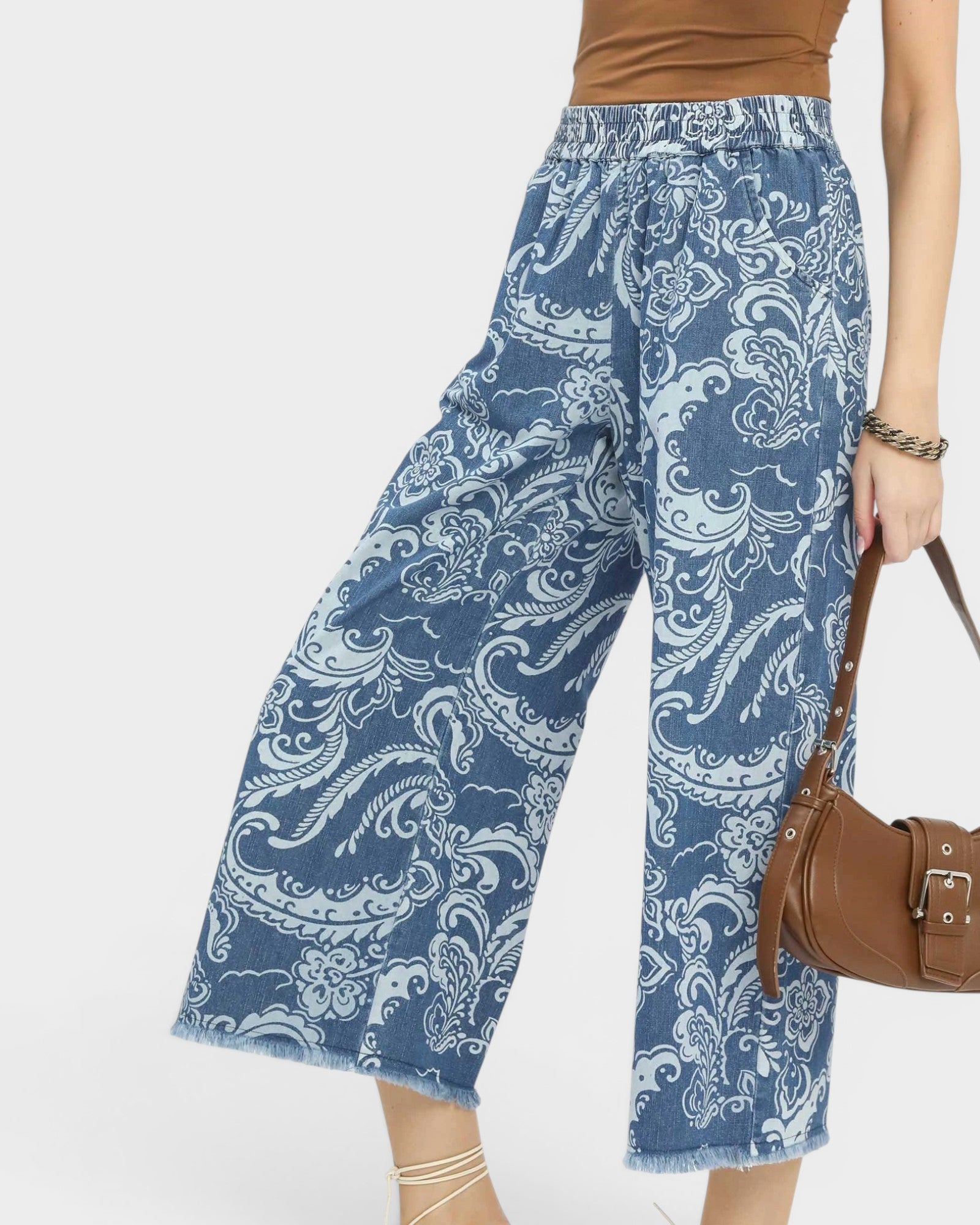 Blue paisley patterned pants worn by a person on a white background