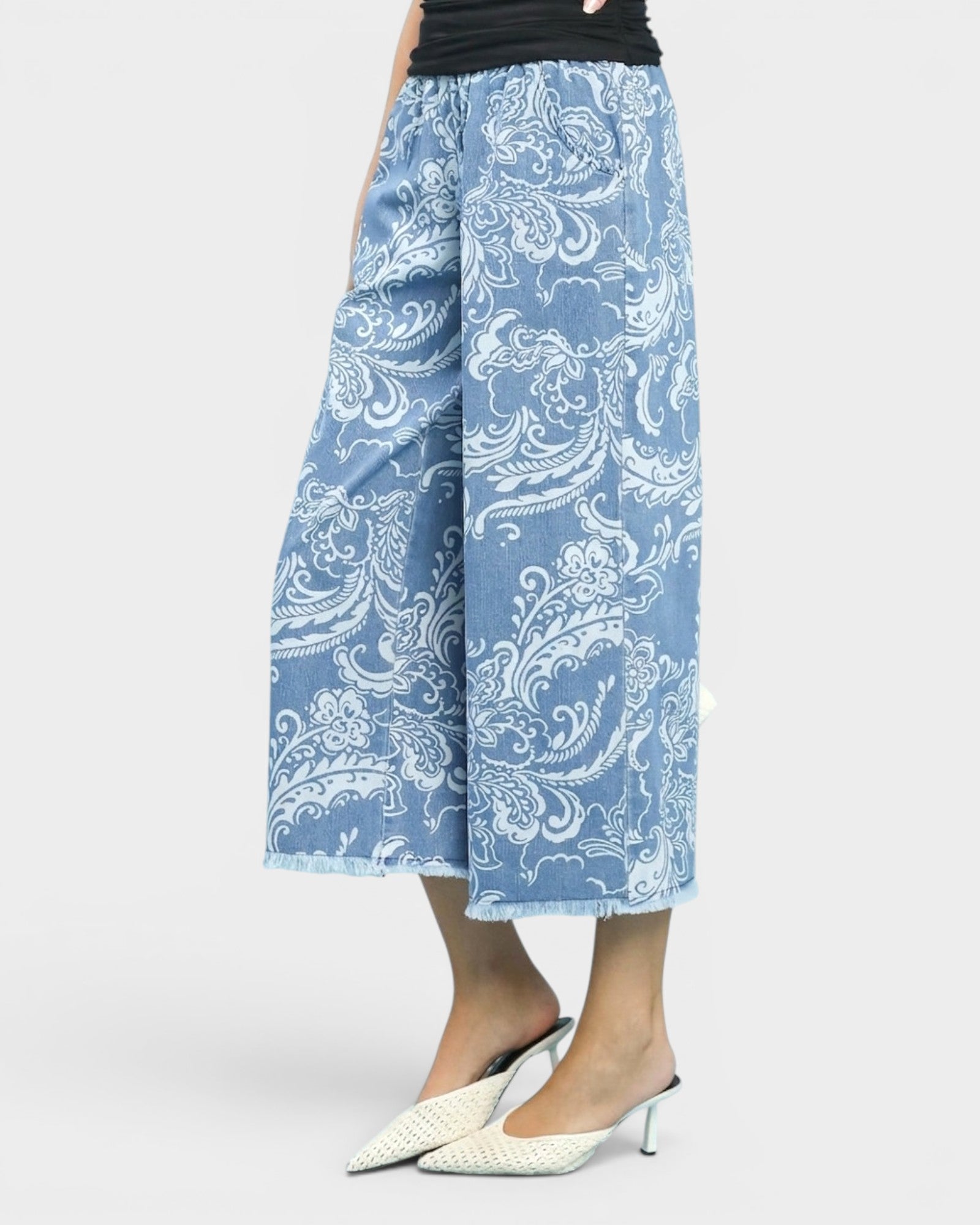 Blue paisley patterned pants worn by a person on a white background