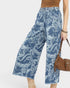 Blue paisley patterned pants worn by a person on a white background