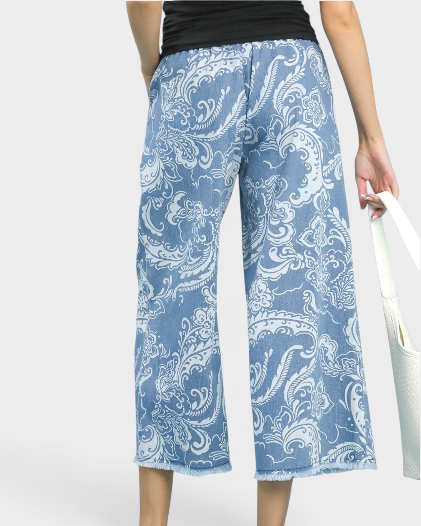 Blue paisley patterned pants worn by a person on a white background