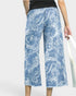 Blue paisley patterned pants worn by a person on a white background