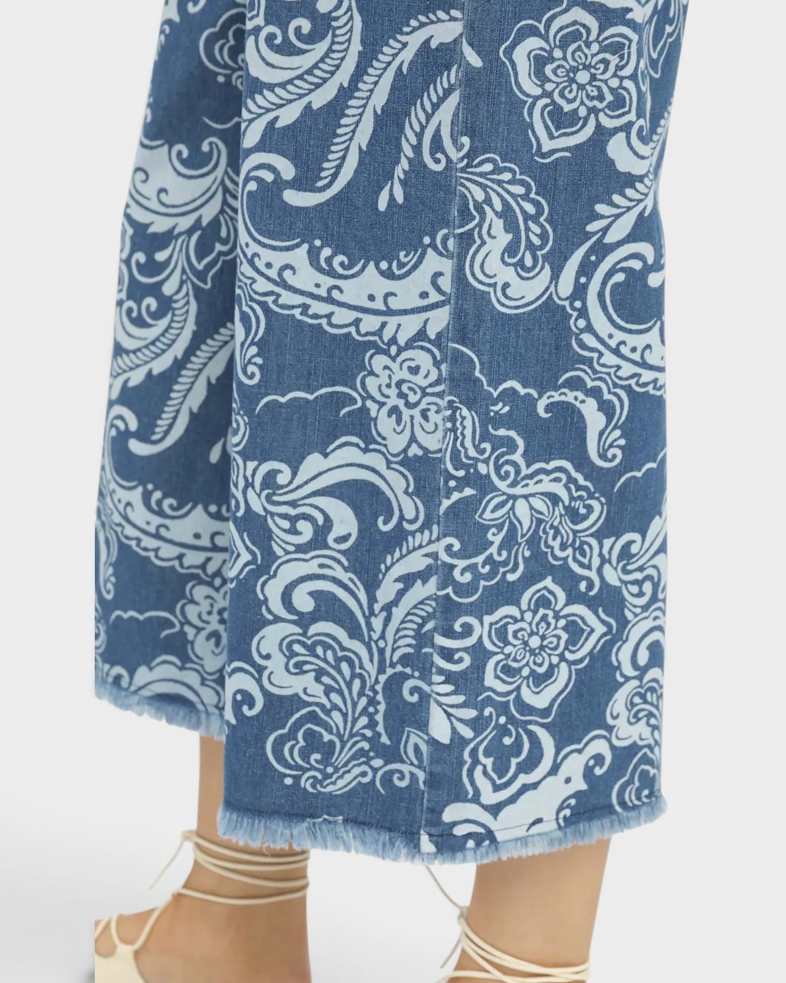 Blue denim pants with white floral pattern on a white background