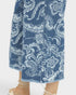 Blue denim pants with white floral pattern on a white background