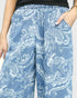 Blue pants with white floral pattern worn by a person on a plain background