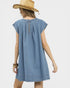 Woman wearing a blue denim dress and straw hat on a white background