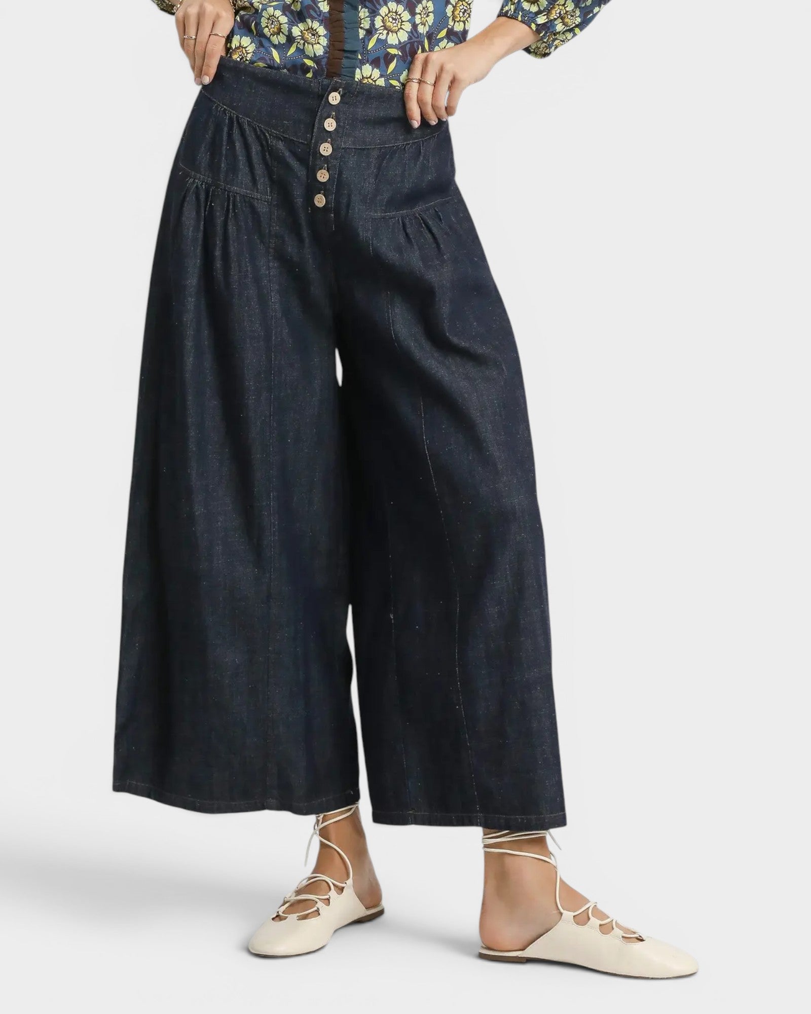 Dark blue wide-leg pants worn by a person on a white background