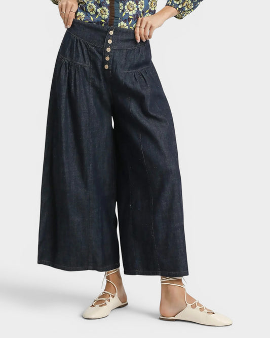 Dark blue wide-leg pants worn by a person on a white background