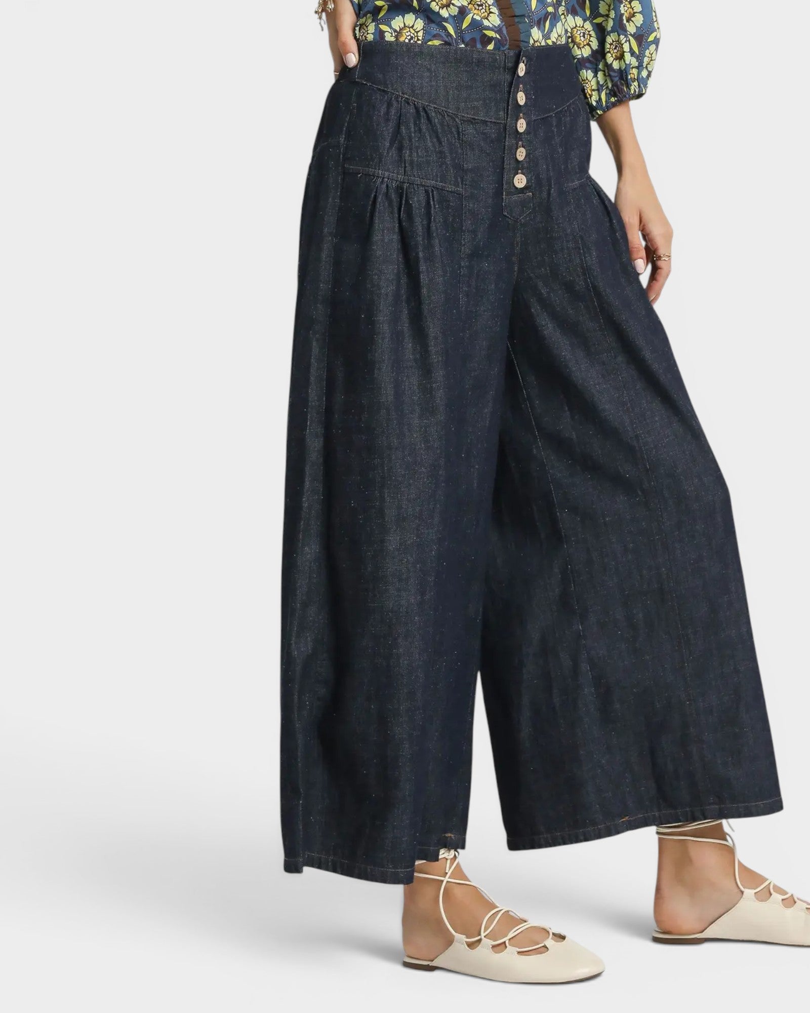 Person wearing dark denim wide-leg pants on a white background