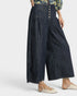Person wearing dark denim wide-leg pants on a white background