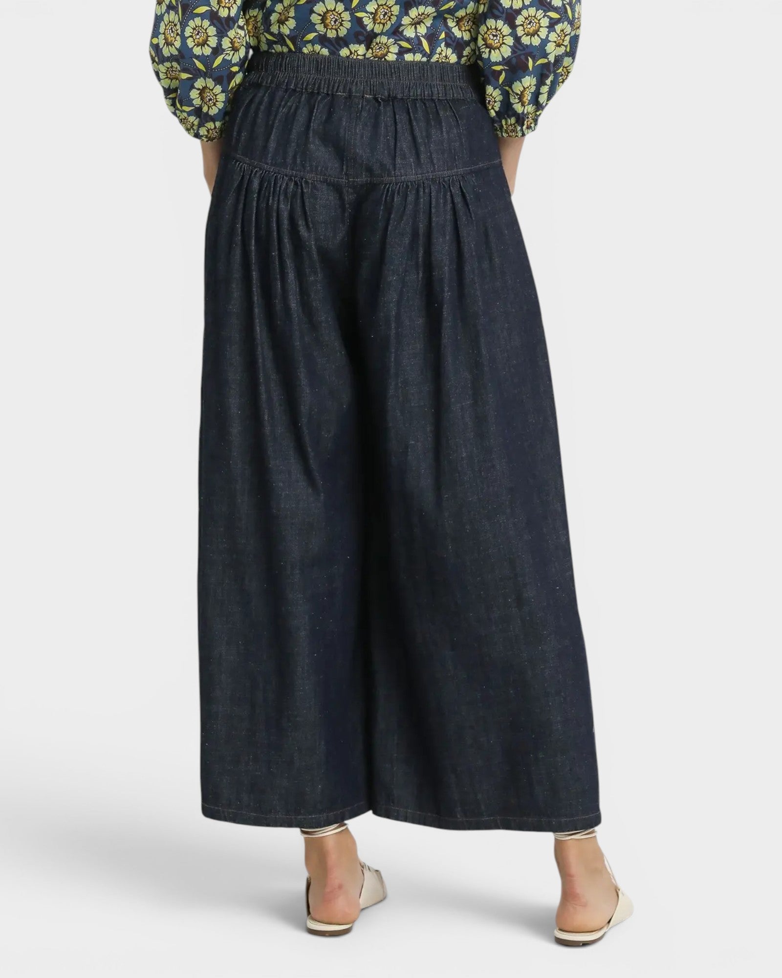 Dark denim pants worn by a person on a white background