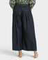 Dark denim pants worn by a person on a white background