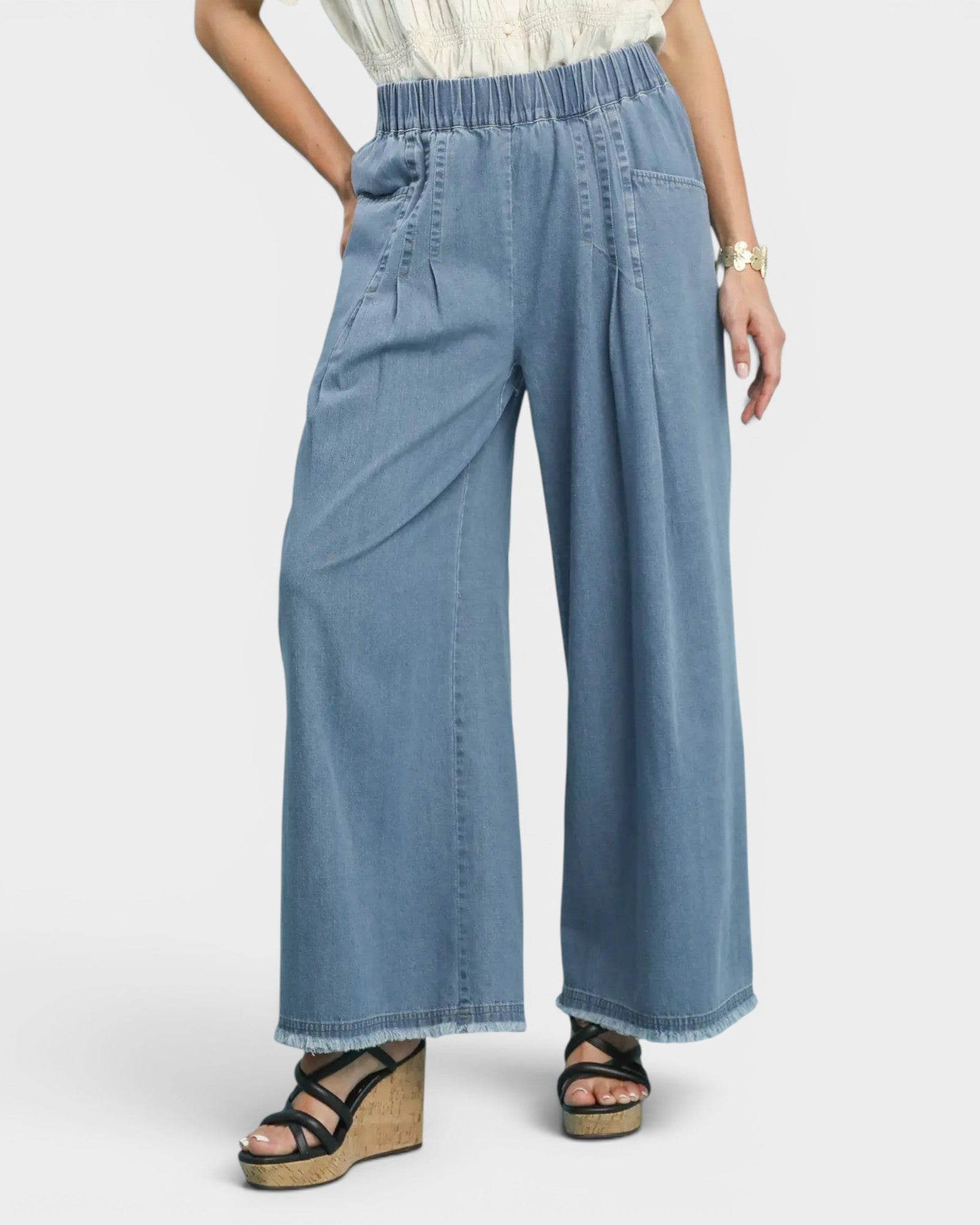 Blue wide-leg jeans worn by a person on a white background