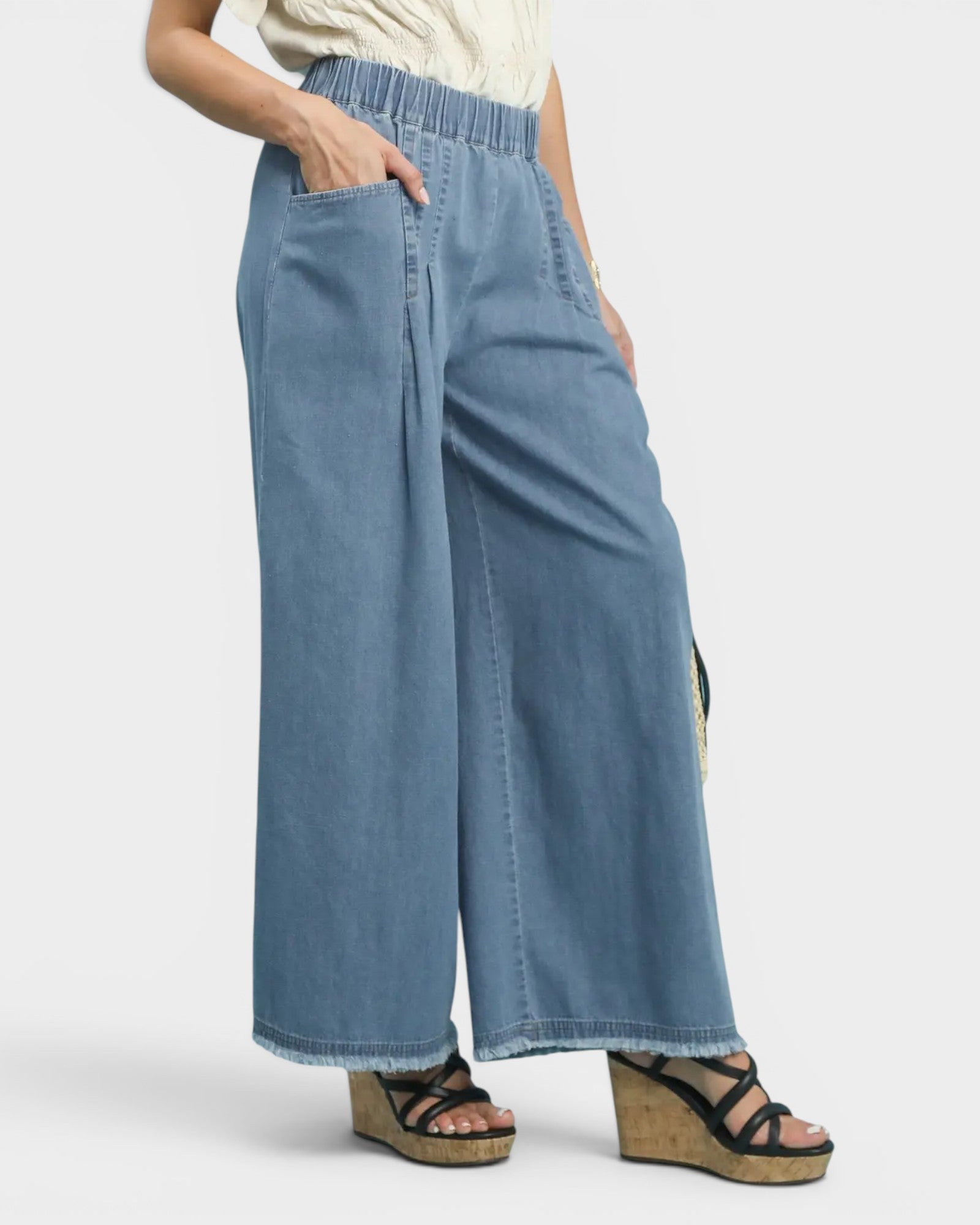 Person wearing blue wide-leg jeans on a white background
