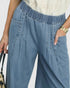Blue denim pants worn by a person on a white background