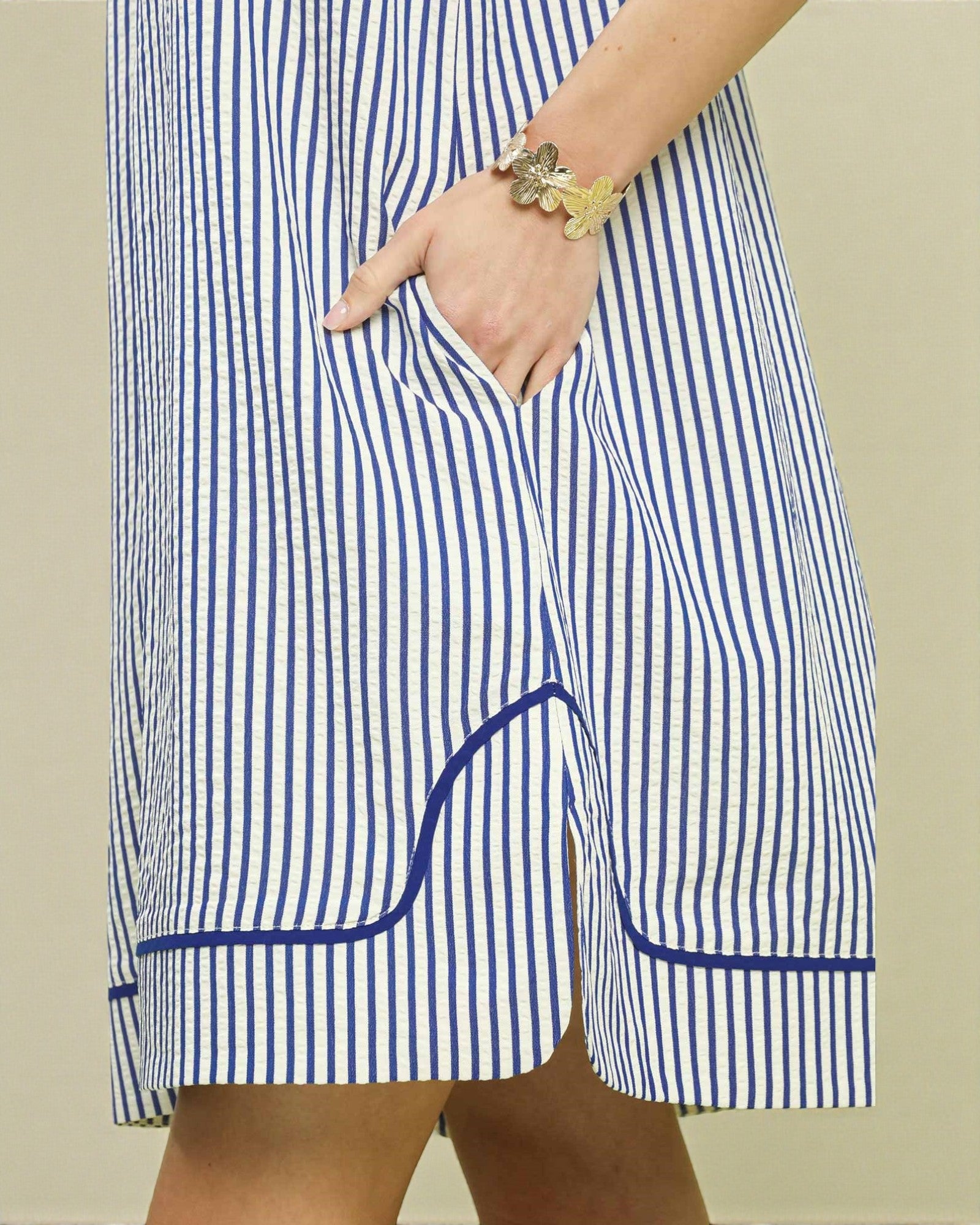 Blue and white striped shorts with a pocket on a neutral background