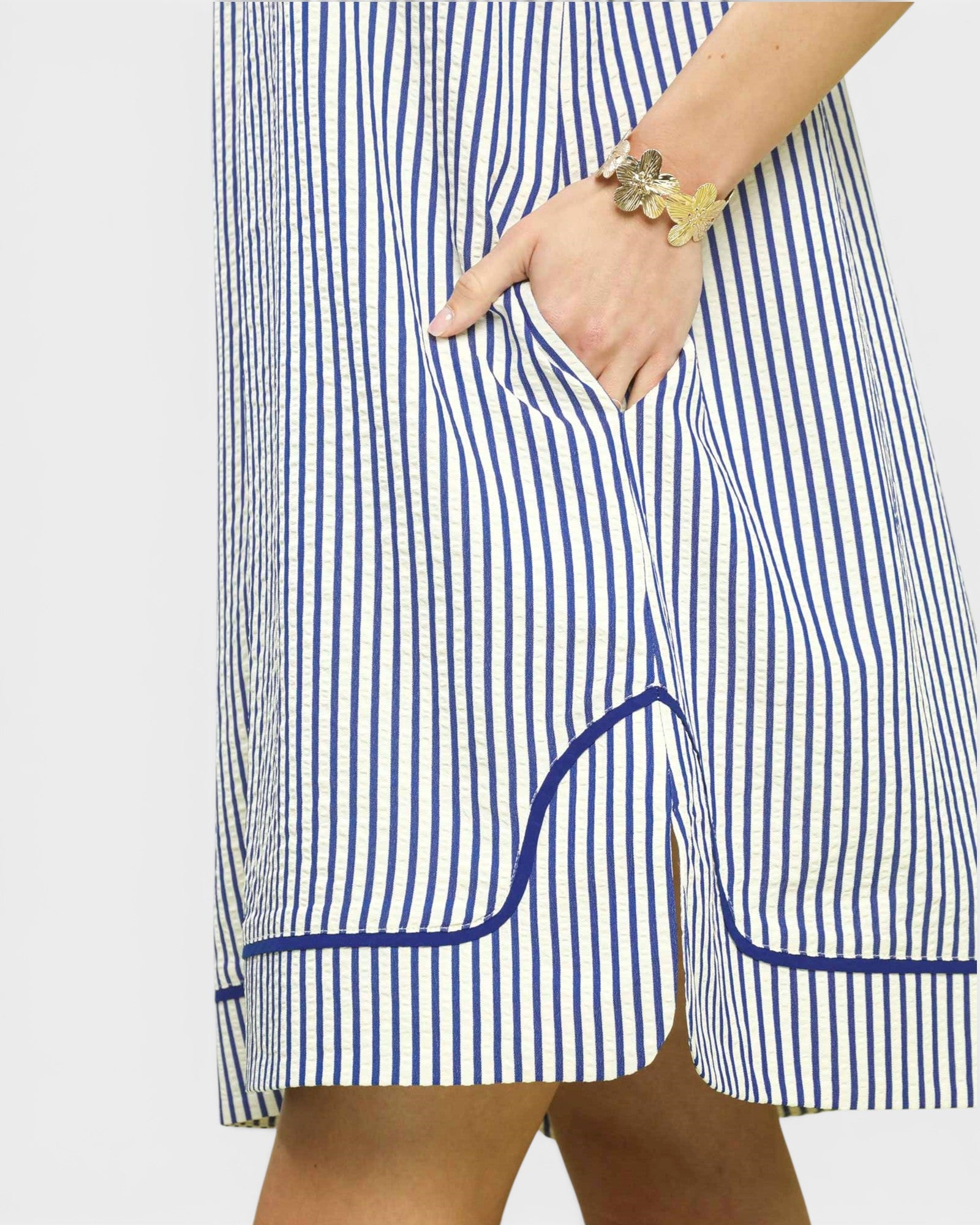 Blue and white striped dress with a pocket on a plain background