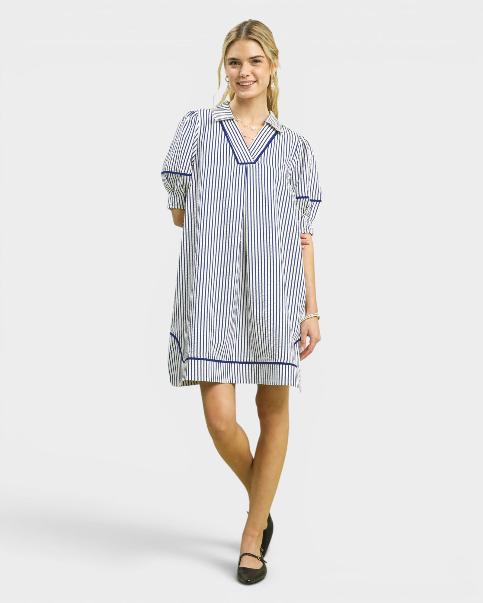 Woman wearing a blue and white striped dress on a white background
