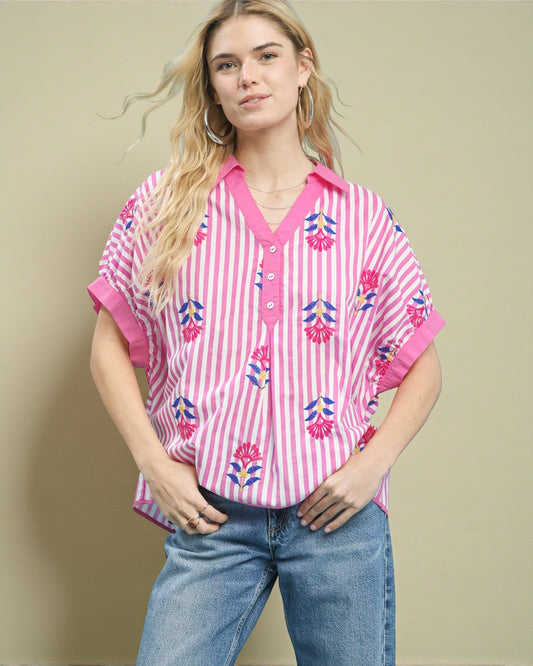 Woman wearing a pink and white striped shirt with floral patterns on a beige background