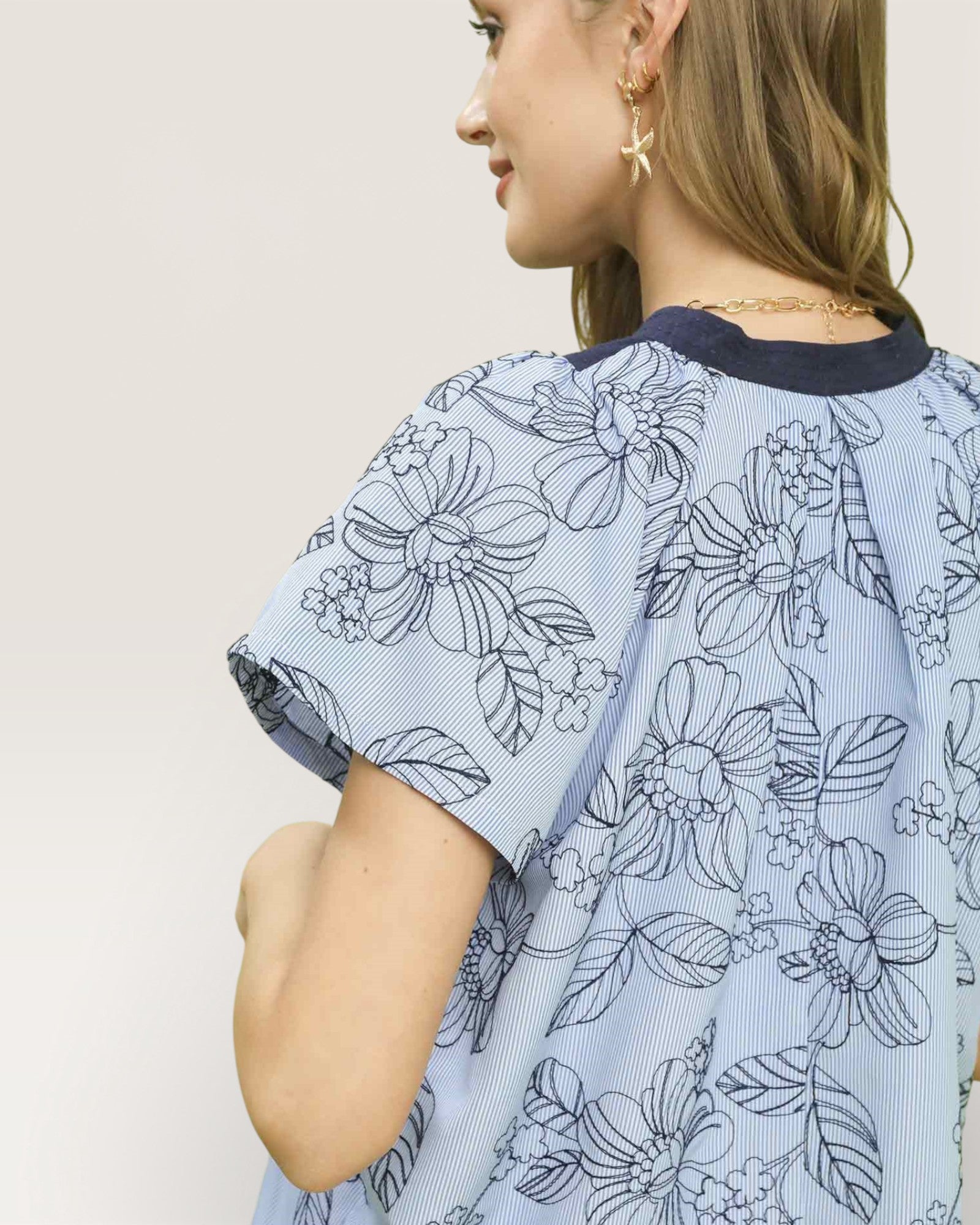 Woman wearing a blue floral dress with a plain background