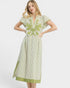 Woman wearing a green and white striped dress with floral embroidery on a white background