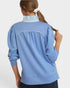 Person wearing a blue long-sleeve top with a white background