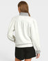 Person wearing a light gray jacket with black shorts on a white background