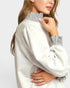 White sweater with striped collar worn by a person on a white background