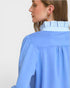 Woman wearing a light blue shirt with a white background