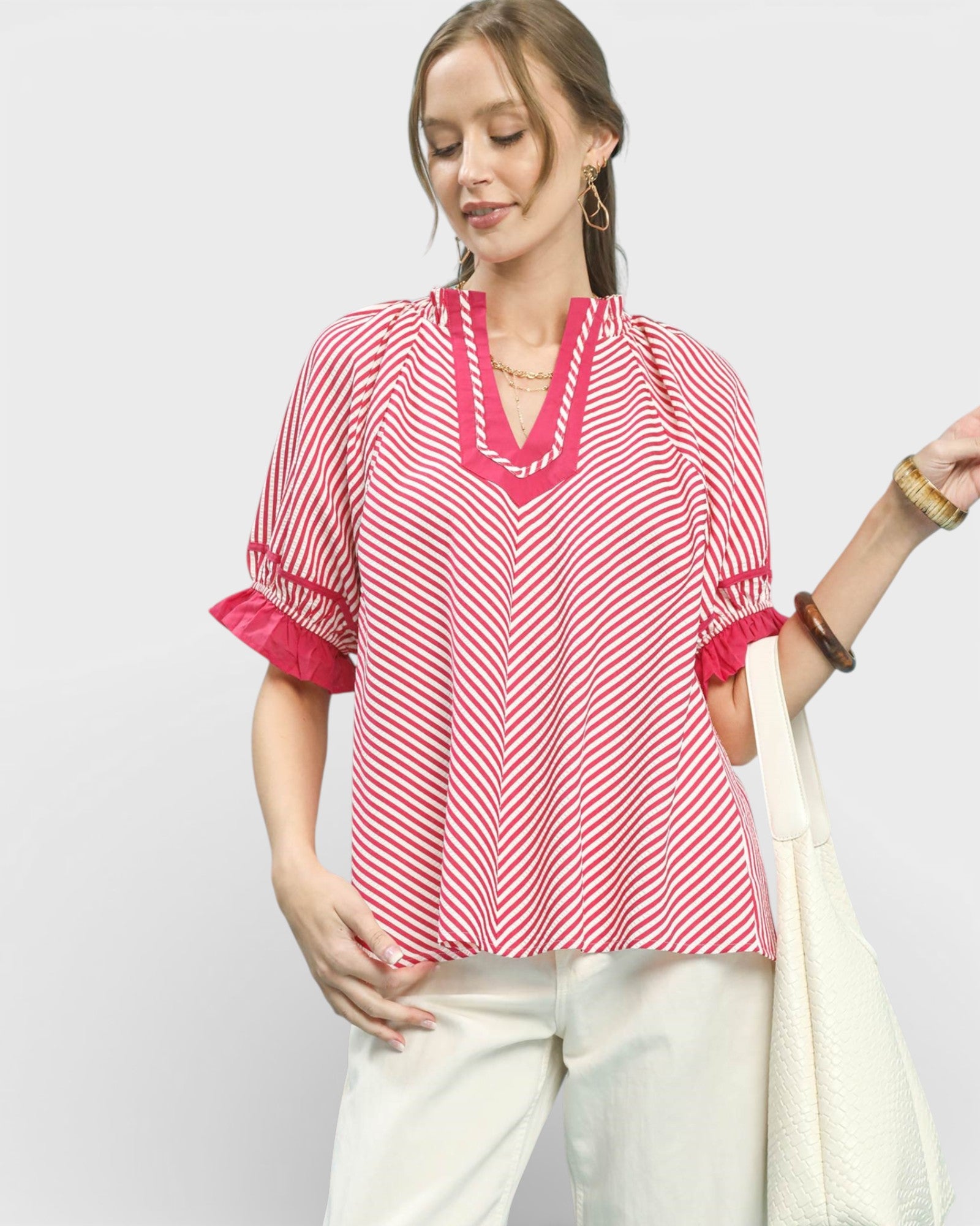Woman wearing a red and white striped blouse with a plain background