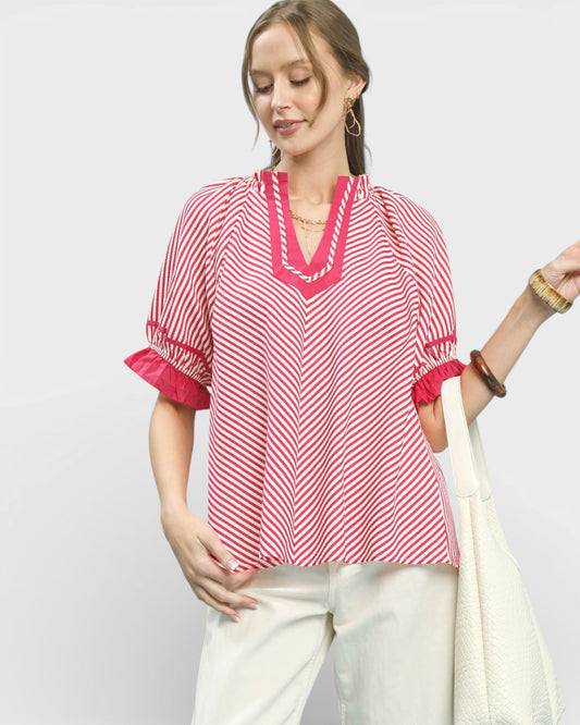 Woman wearing a red and white striped blouse with a plain background