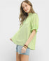 Woman wearing a green striped shirt and denim shorts on a white background